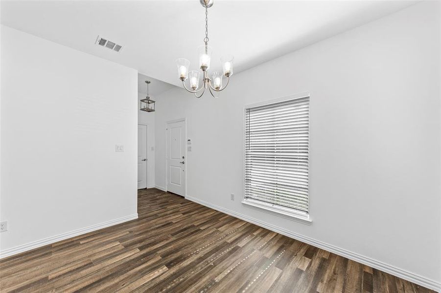 Unfurnished room featuring dark wood-type flooring and a chandelier