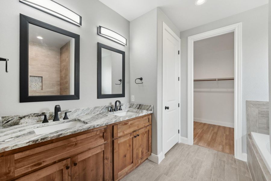 Full bath featuring a bath, baseboards, and a sink