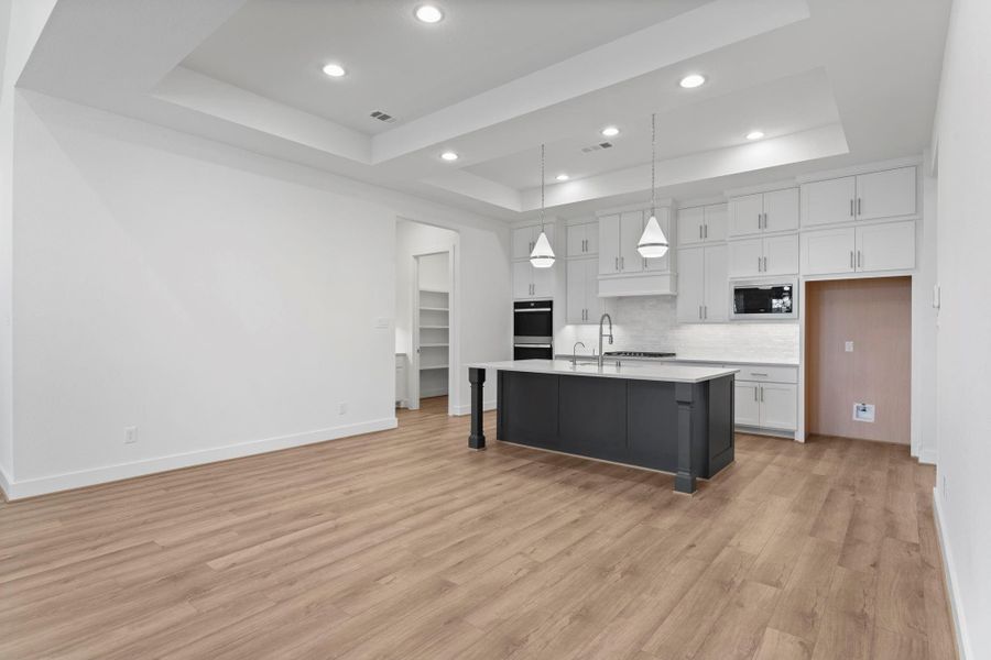 Kitchen with ceiling-height cabinetry, quartz countertops, under-cabinet lighting, and a gas cooktop. Kitchen with ceiling-height cabinetry, quartz countertops, under-cabinet lighting, and a gas cooktop.