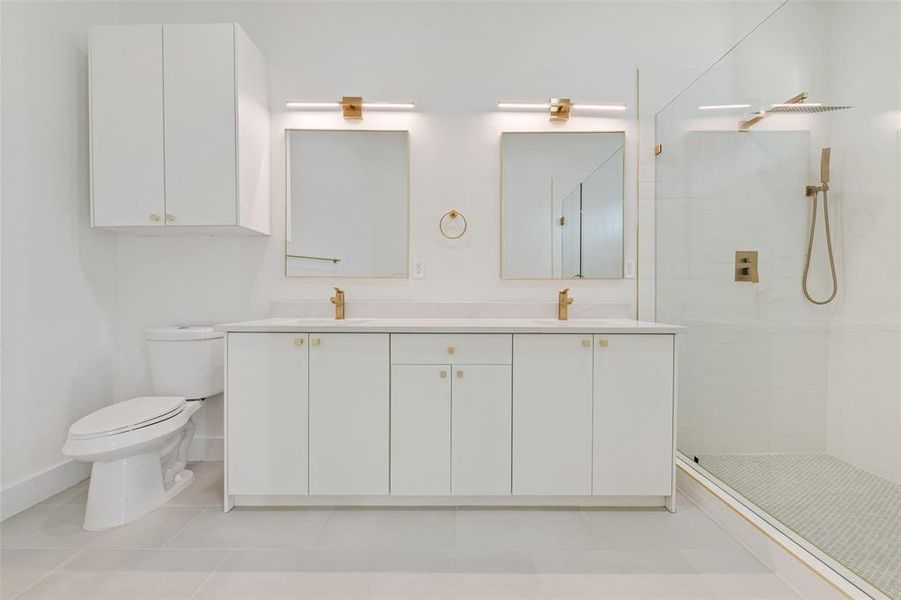 Bathroom with a stall shower, double vanity, and light tile patterned floors Bathroom with a stall shower, double vanity, and light tile patterned floors