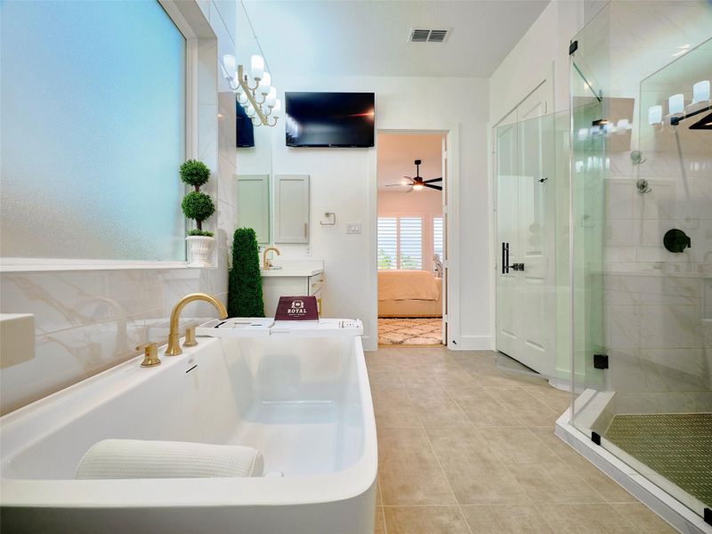 Discover luxury in this spacious primary bathroom with a jacuzzi soaking tub, custom glass-enclosed shower with dual heads, dual vanities, and a stylish double-door linen closet.