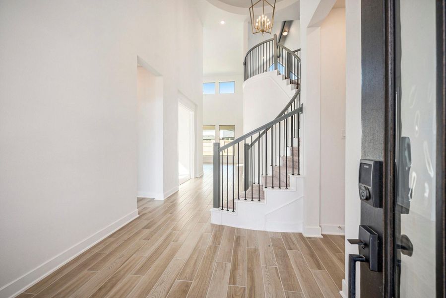 The elegant double front doors open to a bright and open floor plan with a spacious family room, informal dining area, and private study—perfect for work or relaxation.