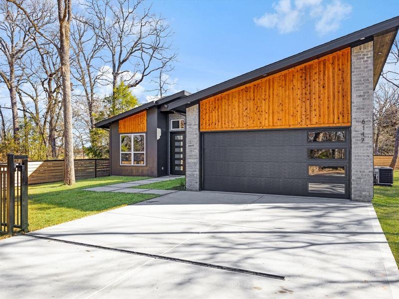 View of front facade featuring driveway and an attached garage