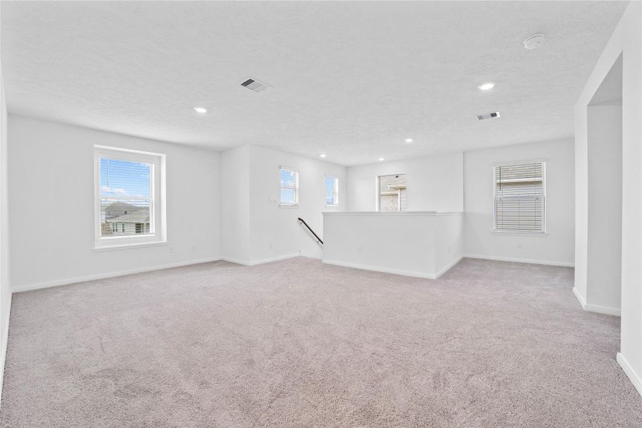 Another perspective of the Game Room, showcasing the staircase, hallway leading to the secondary bedrooms and bathroom, and small intimate corner space outside of the primary suite. Another perspective of the Game Room, showcasing the staircase, hallway leading to the secondary bedrooms and bathroom, and small intimate corner space outside of the primary suite.