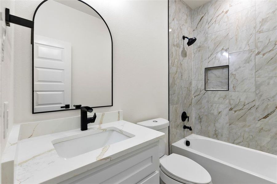 Bathroom featuring a white vanity with a quartz countertop, an undermount sink, and a matte black faucet