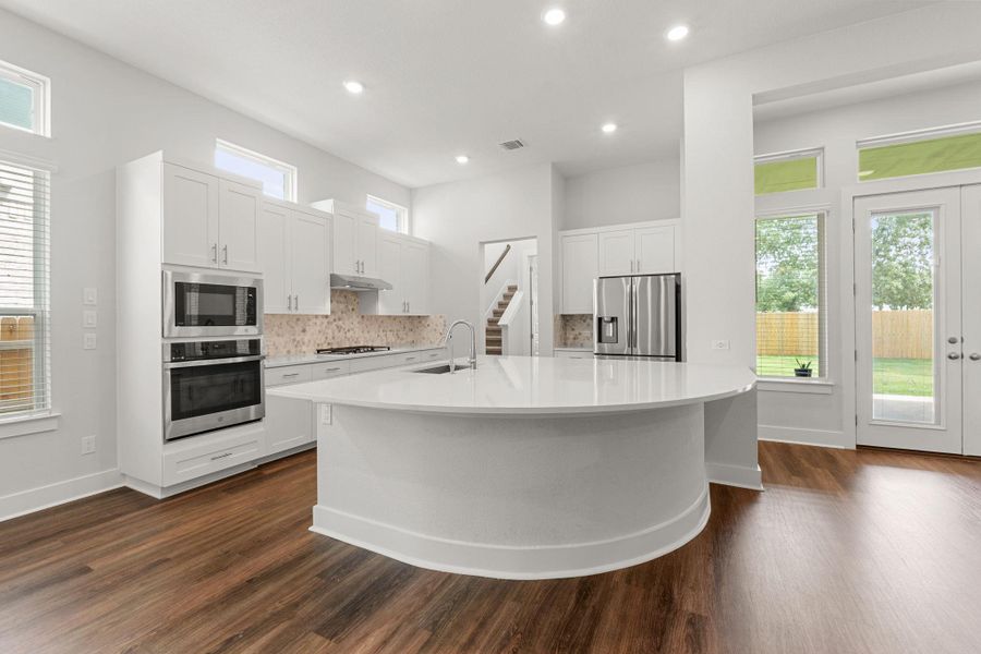 Kitchen featuring stainless steel appliances, dark wood finished floors, a sink, light countertops, and recessed lighting Kitchen featuring stainless steel appliances, dark wood finished floors, a sink, light countertops, and recessed lighting