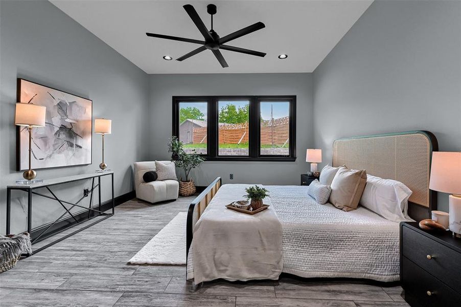 Bedroom featuring vaulted ceiling, wood finished floors, recessed lighting, a ceiling fan, and baseboards Bedroom featuring vaulted ceiling, wood finished floors, recessed lighting, a ceiling fan, and baseboards