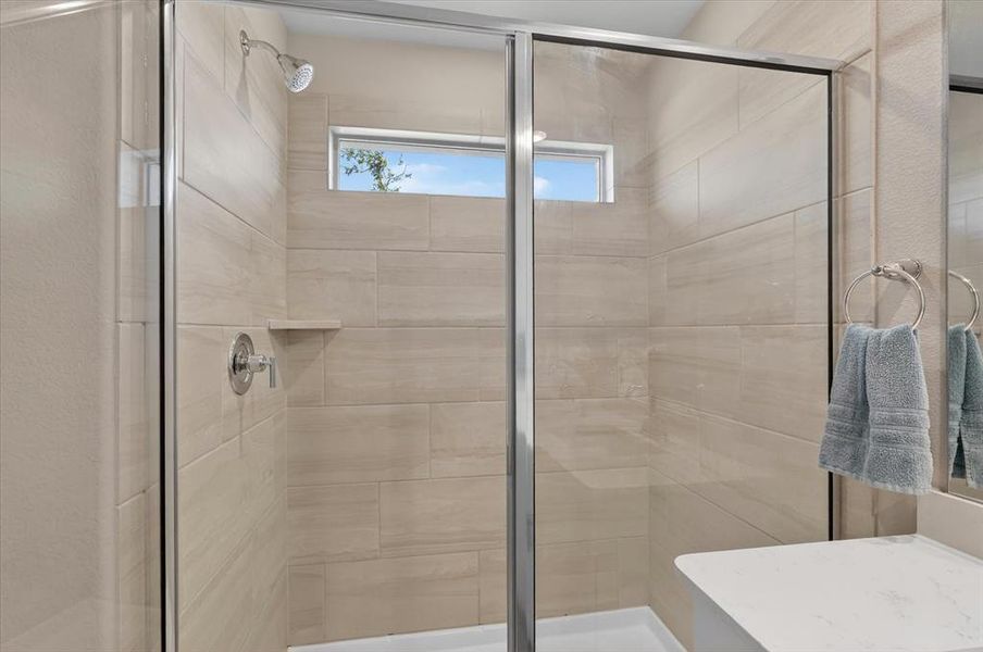 Glass-enclosed shower with full-height tiled walls, an integrated shelf, and a transom window Glass-enclosed shower with full-height tiled walls, an integrated shelf, and a transom window