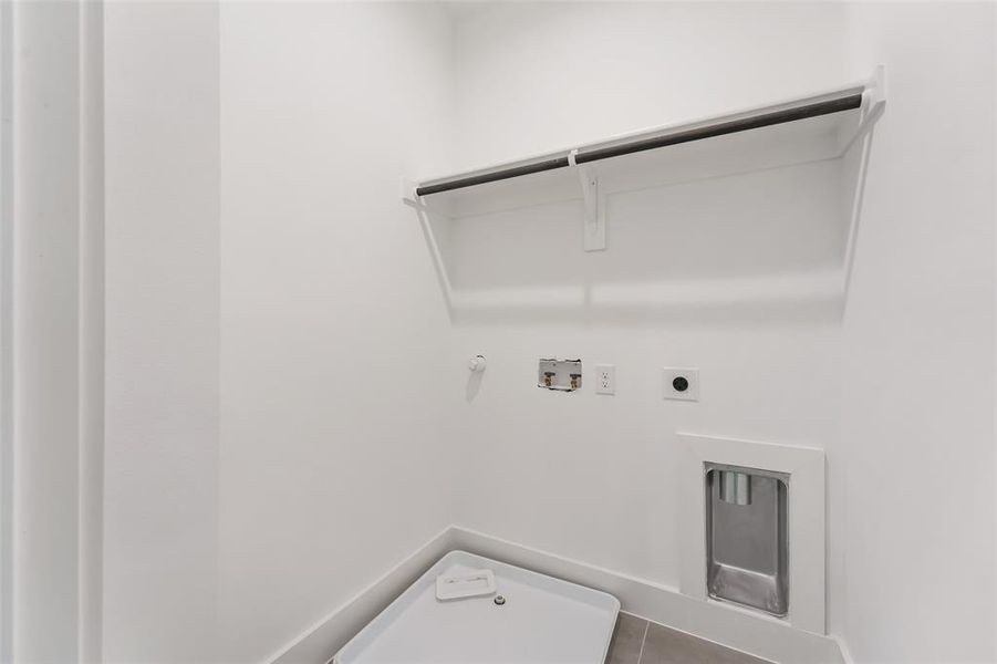 Laundry area featuring hookup for an electric dryer, washer hookup, dark tile patterned floors, and hookup for a gas dryer