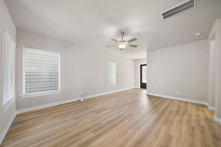 This bright and spacious living room features an open-concept design, seamlessly connecting to the dining and kitchen areas, perfect for entertaining.