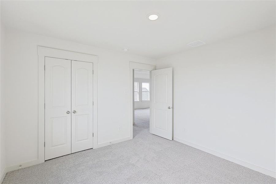 Unfurnished bedroom featuring light colored carpet and a closet