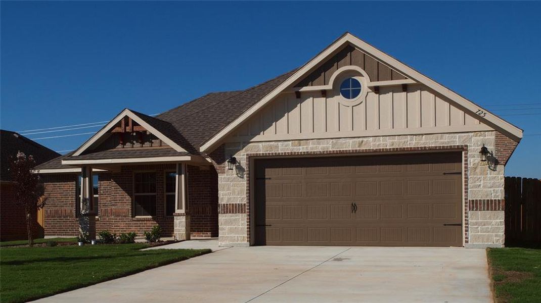 View of front of property with a garage and a front yard