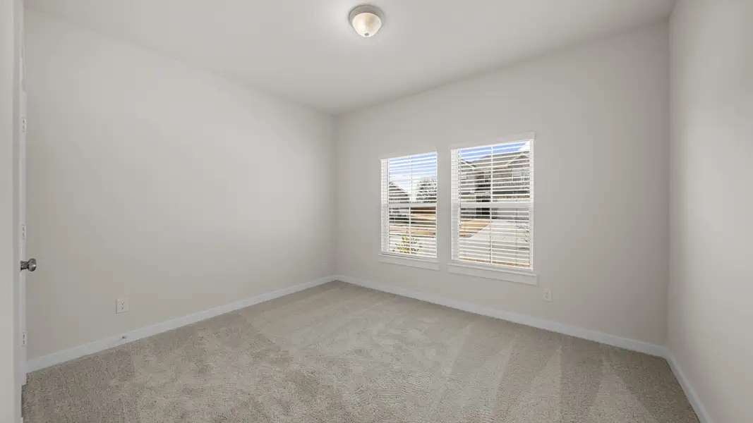 A room with a carpet and a window.