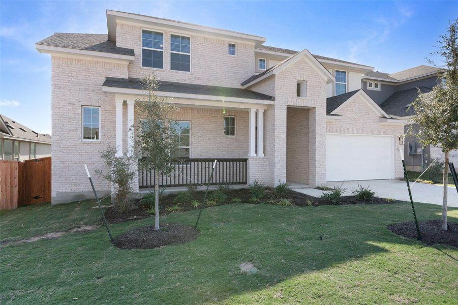 View of front of house featuring brick siding, a porch, a garage, and driveway