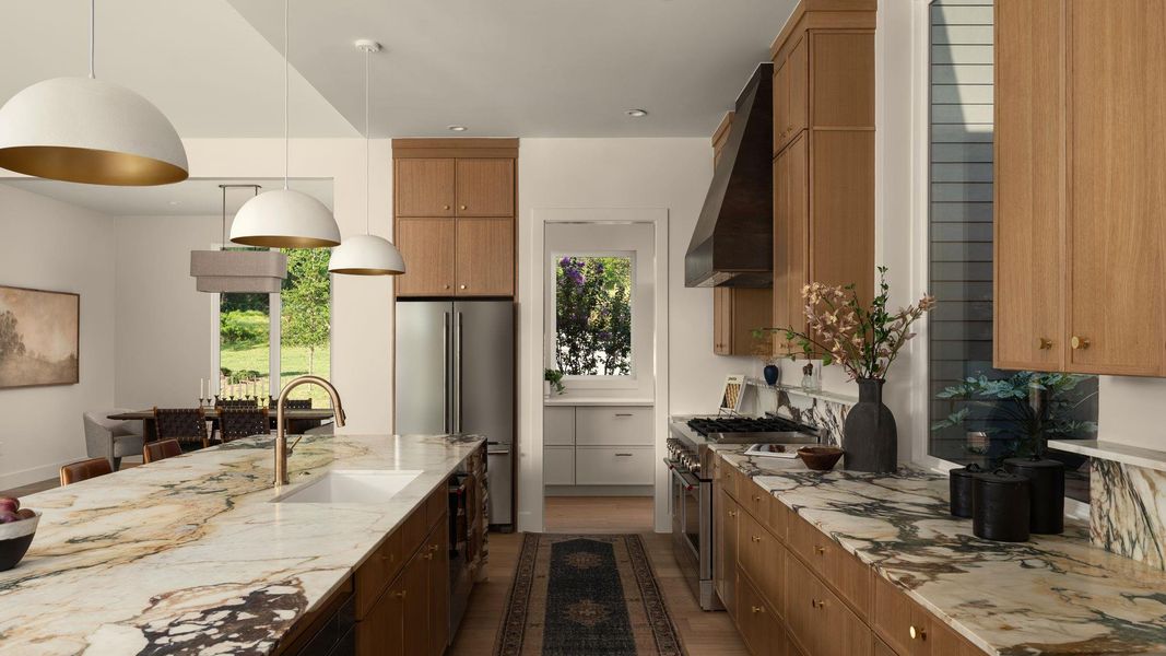 A well-lit culinary space showcases a sprawling island with integrated sink, leading to the butler's pantry A well-lit culinary space showcases a sprawling island with integrated sink, leading to the butler's pantry