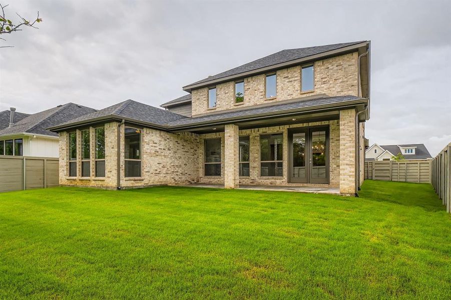 Back of property with a fenced backyard, brick siding, a patio, and a shingled roof Back of property with a fenced backyard, brick siding, a patio, and a shingled roof