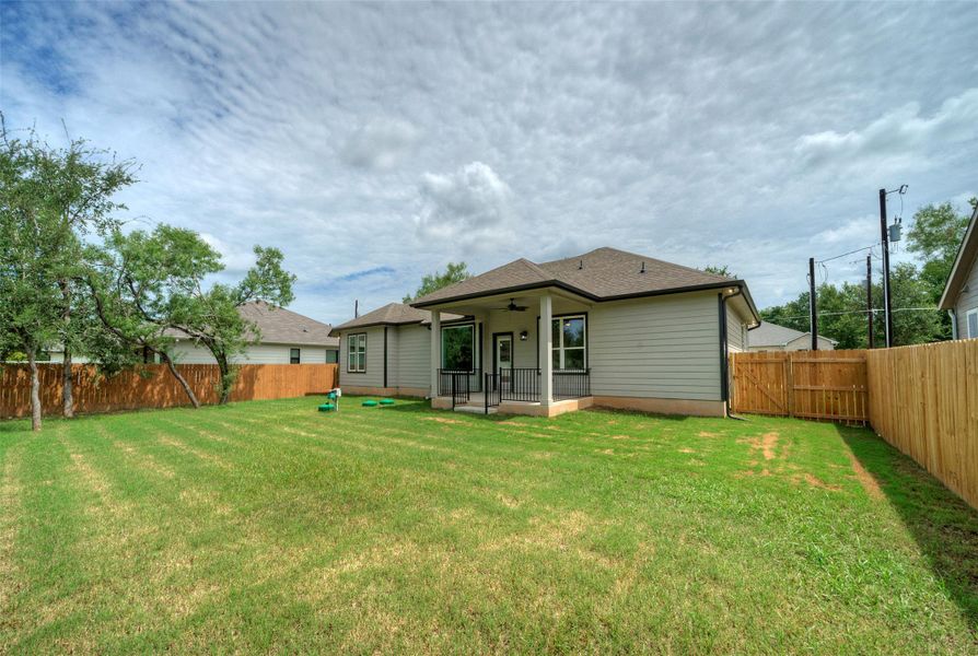 Back of house with ceiling fan, a fenced backyard, a shingled roof, and a patio area Back of house with ceiling fan, a fenced backyard, a shingled roof, and a patio area