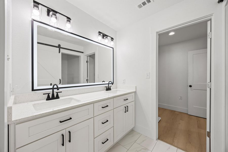 Full bath featuring double vanity and baseboards Full bath featuring double vanity and baseboards