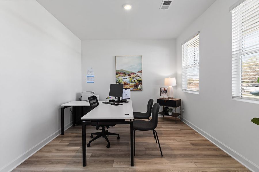 A room with a desk and chairs.