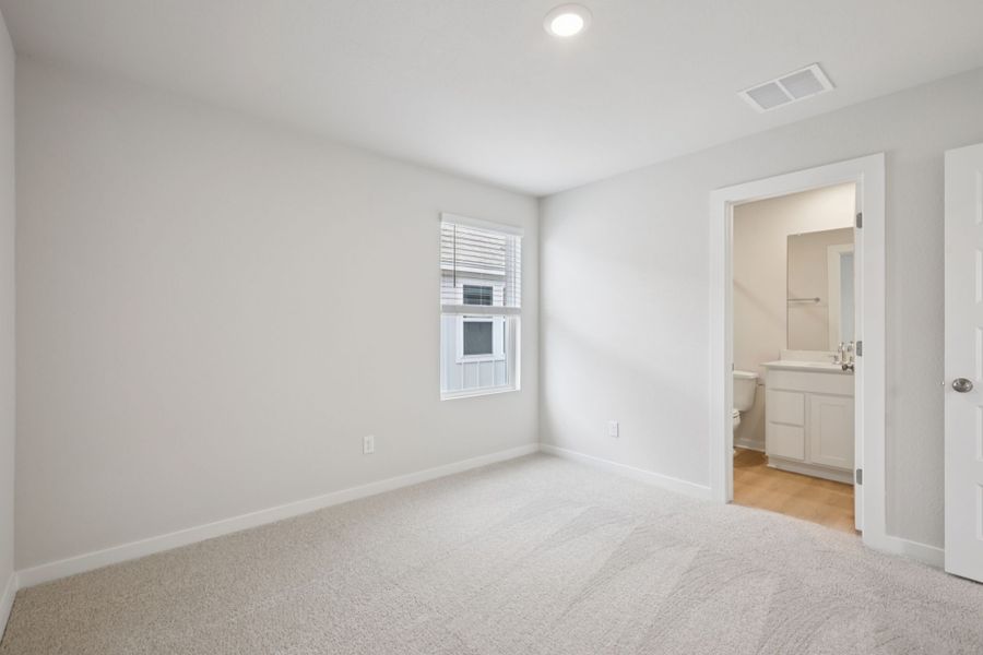 A room with a white carpet and a window.