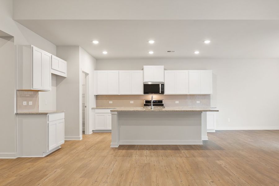 A kitchen with white cabinets.