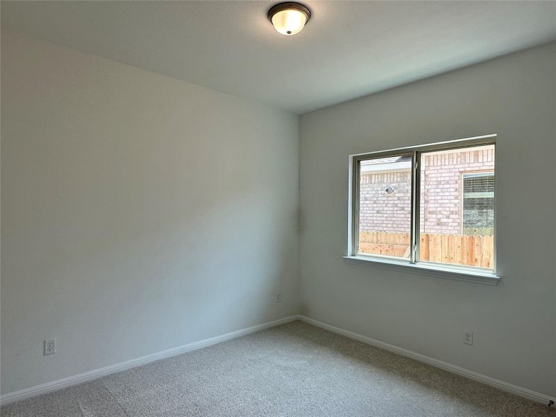Carpeted empty room featuring baseboards