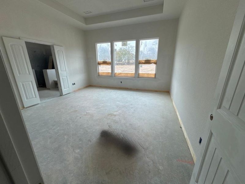Unfurnished bedroom with a raised ceiling and baseboards