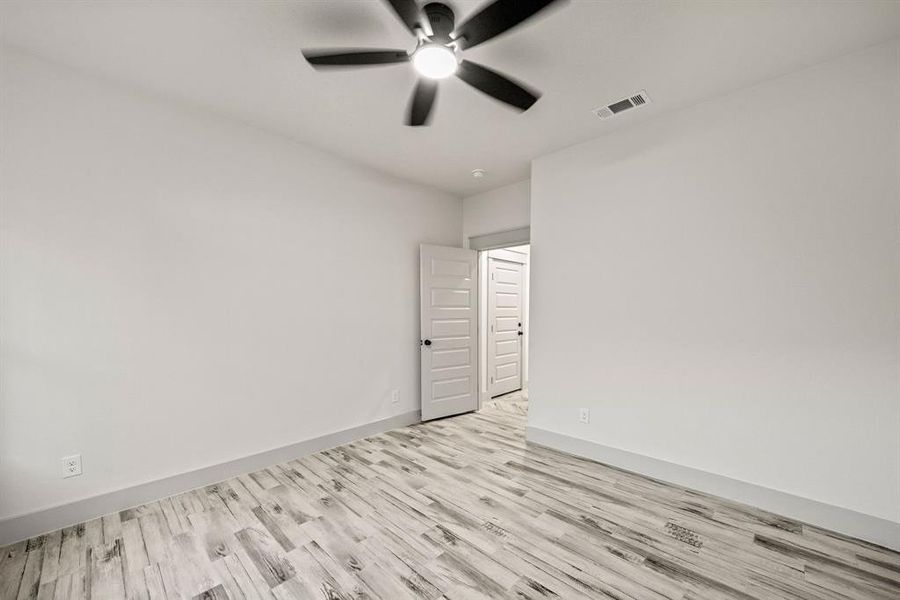 Spare room featuring wood finished floors and a ceiling fan Spare room featuring wood finished floors and a ceiling fan