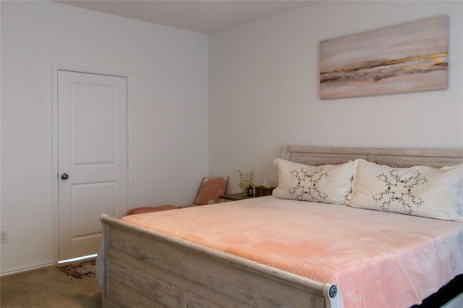 Spacious owner’s suite captured from an angle, showcasing the smooth flow into the master bathroom.