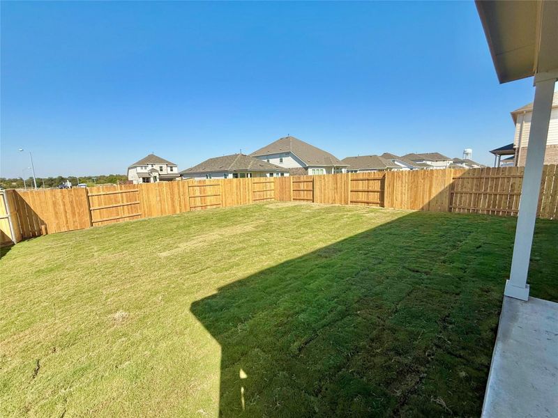 Fenced backyard with a residential view Fenced backyard with a residential view