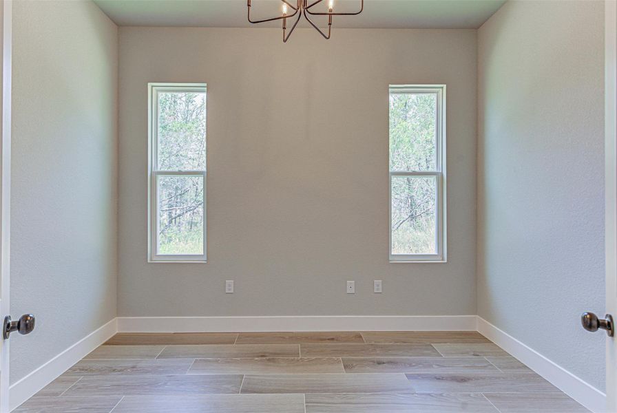 Flex/ Office room with natural light, and a chandelier.