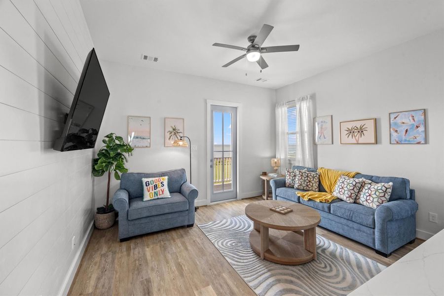 The second-floor game room, with its charming shiplap wall, is the perfect spot to unwind and have fun. It opens up to the south-facing deck, inviting you to enjoy outdoor relaxation and stunning views.