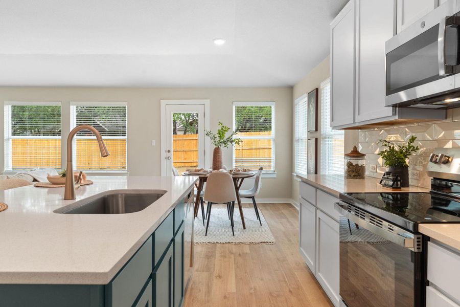 Kitchen with stainless steel appliances, light wood-type flooring, light stone counters, white cabinetry, and recessed lighting Kitchen with stainless steel appliances, light wood-type flooring, light stone counters, white cabinetry, and recessed lighting