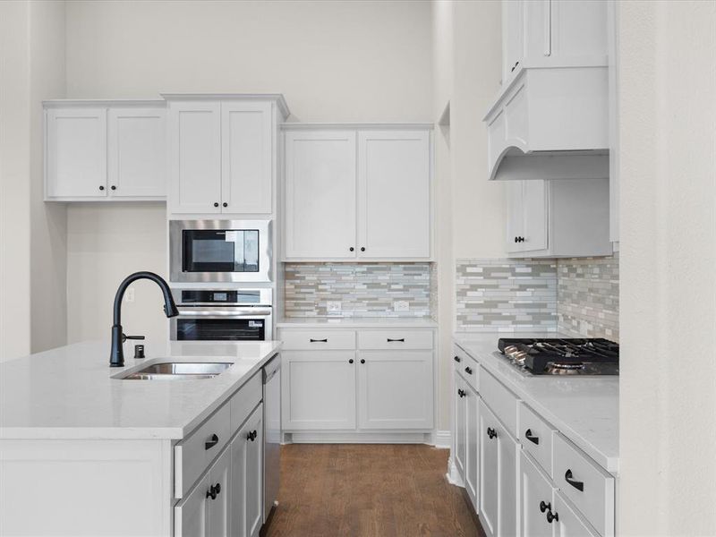 Kitchen with white cabinets, light stone countertops, and stainless steel appliances