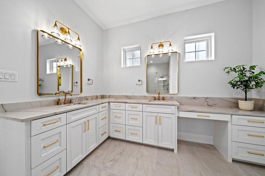 Spacious and serene primary bath featuring dual vanities, elegant lighting, and a dedicated makeup station. Clean lines and natural light create a relaxing, spa-like atmosphere to start and end your day in comfort.