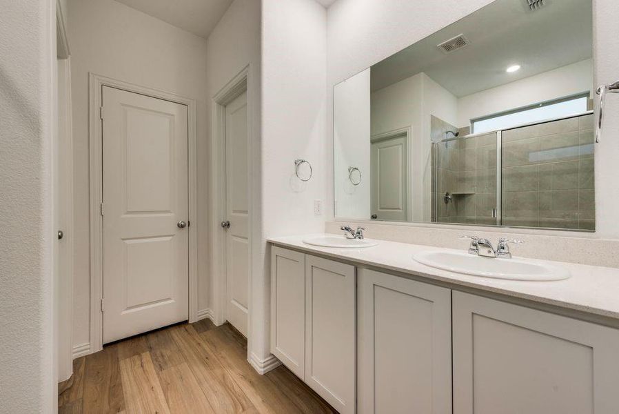 Bathroom with a shower with shower door, wood-type flooring, and vanity