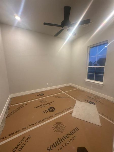 Empty room featuring baseboards and a ceiling fan