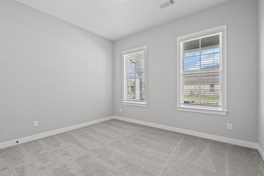 Unfurnished room featuring light carpet and baseboards