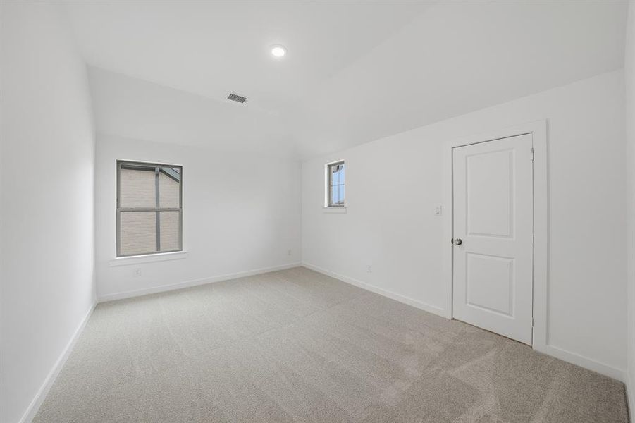 Spare room with light carpet and vaulted ceiling