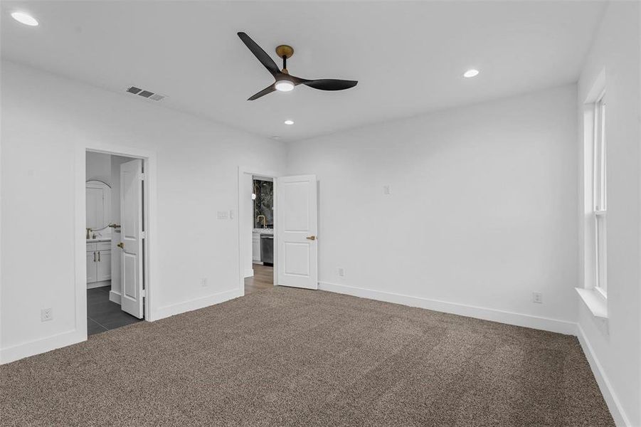 Unfurnished bedroom with dark carpet, recessed lighting, ensuite bath, and a ceiling fan Unfurnished bedroom with dark carpet, recessed lighting, ensuite bath, and a ceiling fan