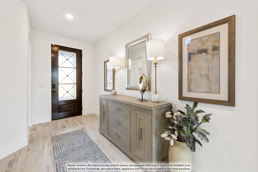 Entryway with dark wood glass-panel front door, gray console table, wall mirror, and light wood floors Entryway with dark wood glass-panel front door, gray console table, wall mirror, and light wood floors