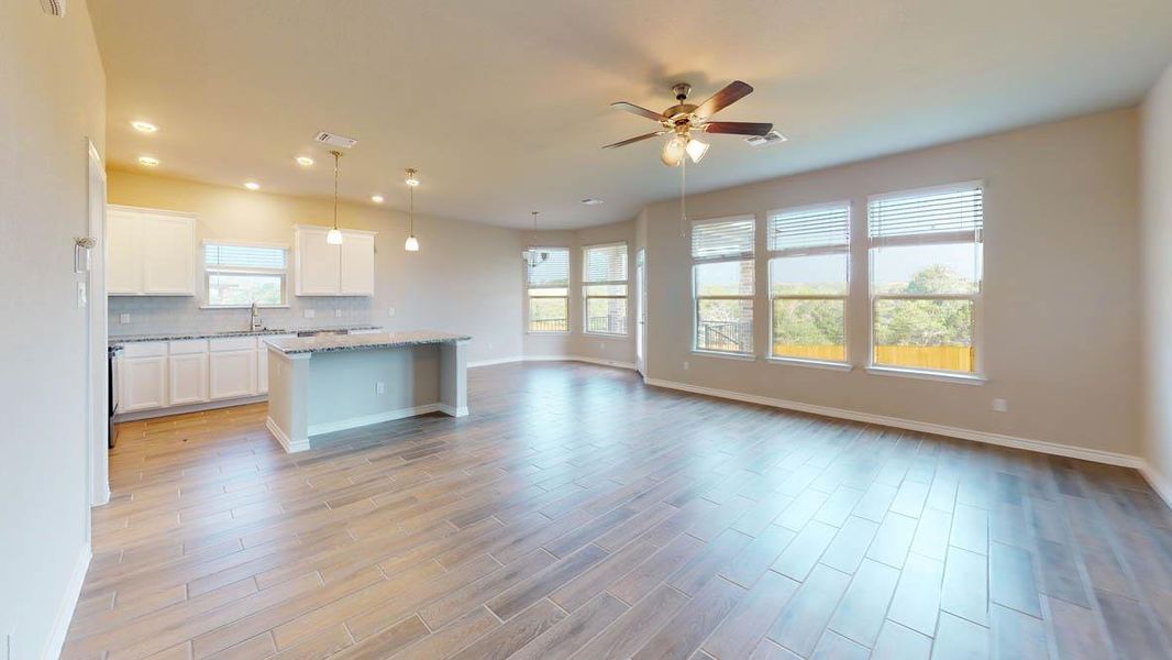 Kitchen with a center island, white cabinets, open floor plan, backsplash, and decorative light fixtures Kitchen with a center island, white cabinets, open floor plan, backsplash, and decorative light fixtures
