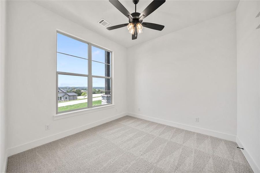 Spare room with light colored carpet and a ceiling fan Spare room with light colored carpet and a ceiling fan