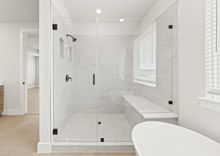 The glass walk-in shower has a wonderful built-in bench and shelves.
