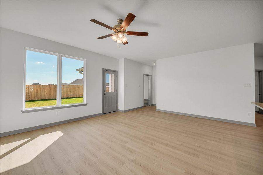 Unfurnished living room with light wood-style floors and a ceiling fan
