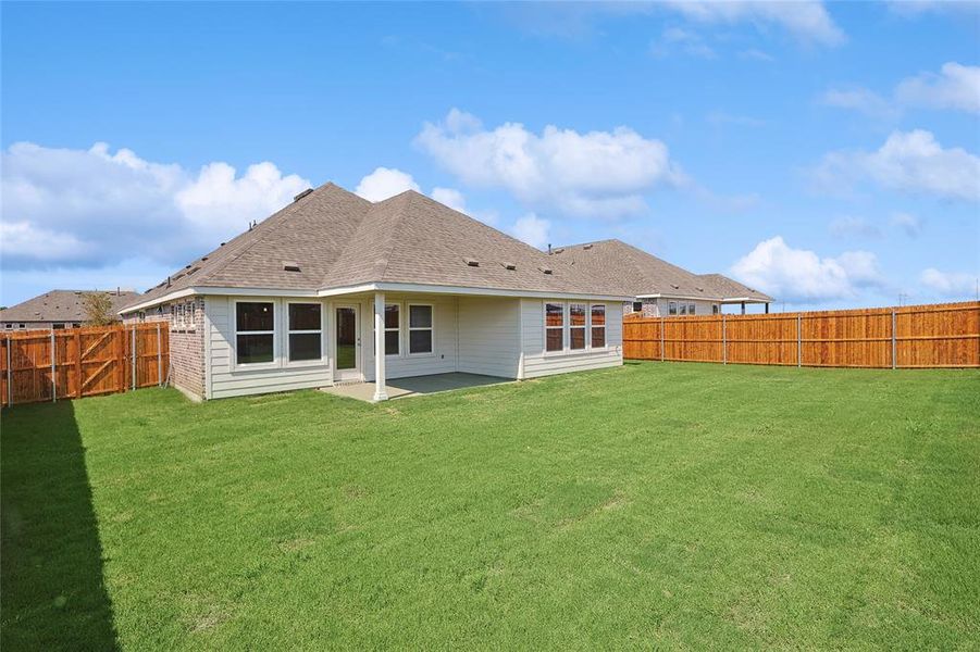 Rear view of house featuring a lawn and a patio