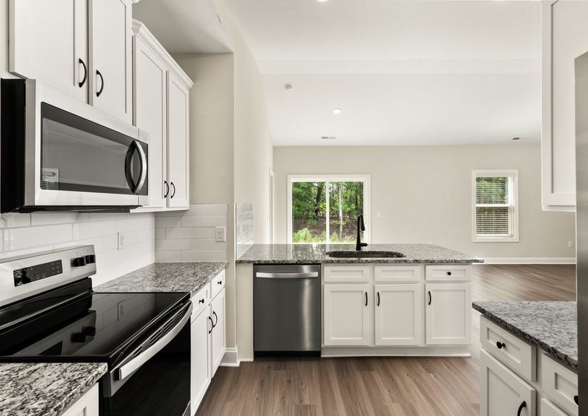 The kitchen boasts beautiful white cabinets and granite countertops.