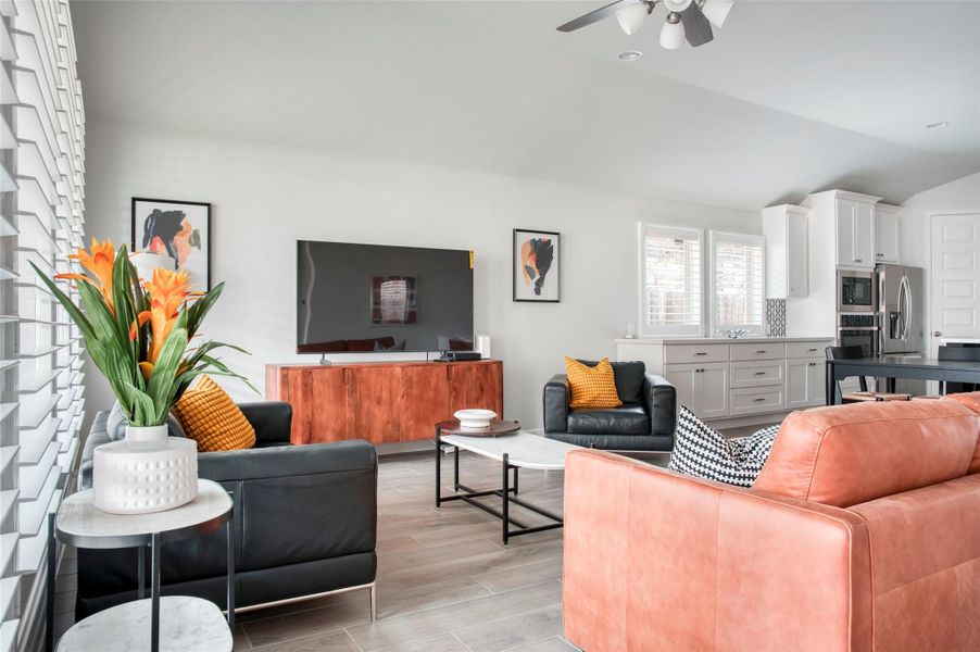 This photo showcases a modern, open-concept living area with a sleek design. It features comfortable seating, a large TV, stylish decor, and a view into a bright, well-equipped kitchen. Ideal for entertaining and relaxation. This photo showcases a modern, open-concept living area with a sleek design. It features comfortable seating, a large TV, stylish decor, and a view into a bright, well-equipped kitchen. Ideal for entertaining and relaxation.