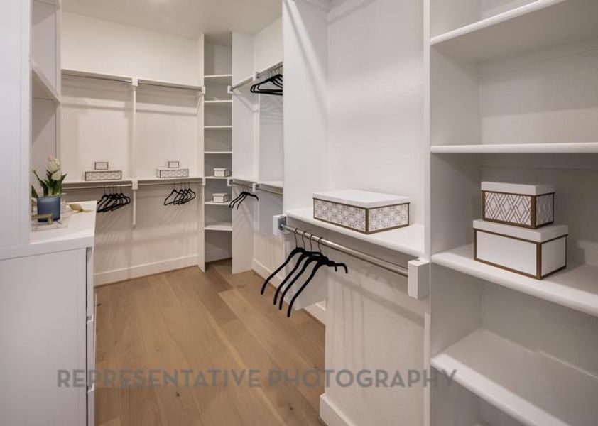 Spacious closet with light wood-style floors Spacious closet with light wood-style floors