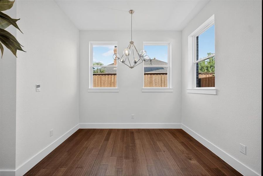 Unfurnished dining area featuring dark wood-type flooring and a chandelier